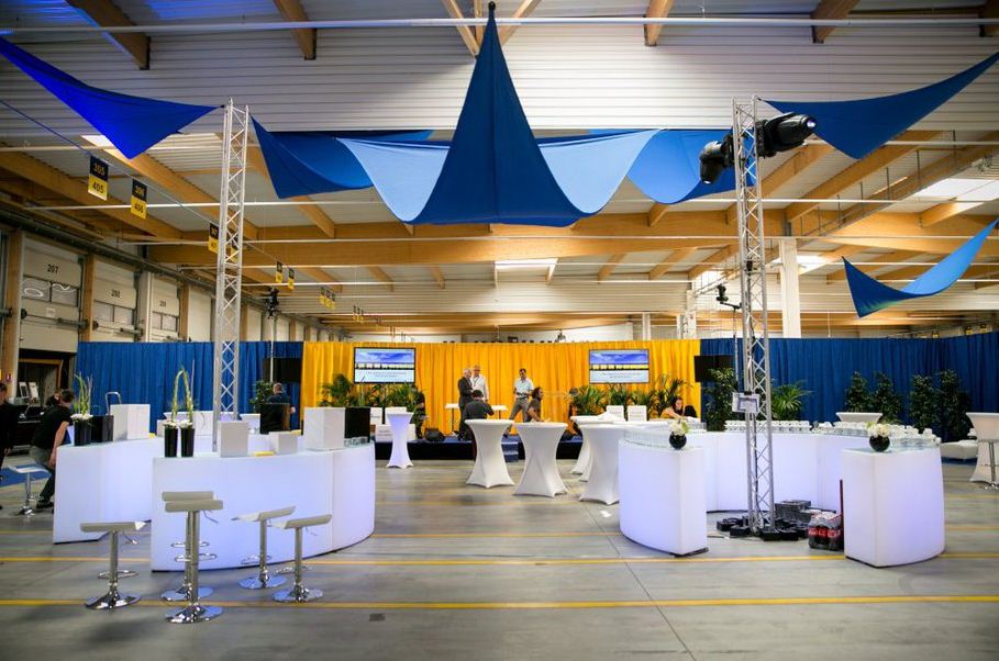 Hall aménagé en espace de réception, voilages, mange-debout et structures